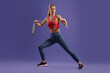 © New Africa - Athletic woman exercising with elastic resistance band on purple background