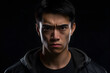 © lucky pics - serious young adult Asian man, head and shoulders portrait on black background. Neural network generated photorealistic image. Not based on any actual person or scene.
