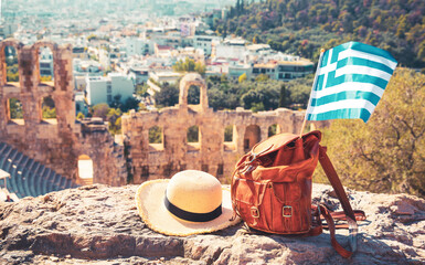 Bag, summer hat and Greek flag at theatre of Herodion Atticus, Athens Acropolis in Greece- travel, tour tourism, vacation concept