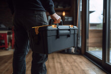 Close-up On An Electrician Carrying A Toolbox While Working At A House - Domestic Life Concept