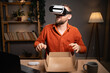 © Andrii Lysenko - Handsome man creating online content for his tech channel, daily vlog, unboxing a new VR Glasses at home, online sales.