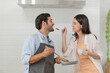 Happy young couple cooking together in the kitchen, feeding each other in their kitchen at home