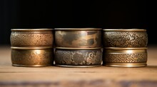 A Stack Of Antique Brass Napkin Rings With Intricate Etching And Patina