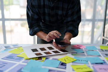 Developer, UI, UX designer, mobile app interface creation process, wireframe On the work desk for mobile app, phone app development plan layout design layout at modern office.