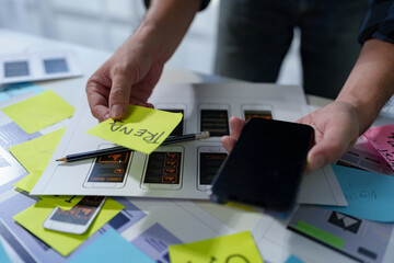 Developer, UI, UX designer, mobile app interface creation process, wireframe On the work desk for mobile app, phone app development plan layout design layout at modern office.
