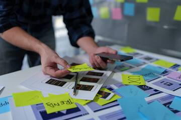 Developer, UI, UX designer, mobile app interface creation process, wireframe On the work desk for mobile app, phone app development plan layout design layout at modern office.