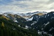 Alpejski krajobraz jesienią. Góry, doliny, drzewa oprószone śniegiem, żółte modrzewie