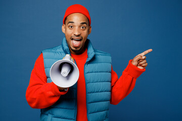 Sticker - Young man of African American ethnicity wear padded vest red hat hold megaphone scream announces discounts sale Hurry up point aside isolated on plain dark royal navy blue background studio portrait.