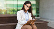 Focused serious pretty young woman secretary manager in suit, glasses write at clipboard work with documents