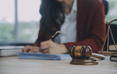 Business and lawyers discussing contract papers with brass scale on desk in office. Law, legal services, advice, justice and law concept picture with film grain effect