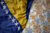 Fototapeta  - colorful waving national flag of bosnia and herzegovina on a euro money background. finance concept