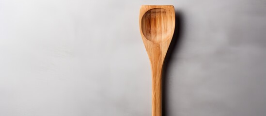 Poster - A gray background showcases a wooden spatula for use in the kitchen