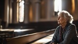 Fototapeta  - Portrait of an elderly woman with grey hair praying in a naturally lit church