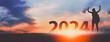 © Peera - New year 2024 traveler woman with sunset sky background travel concept