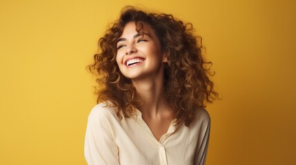 Wall Mural - Portrait of a cheerful young woman wearing yellow shirt standing isolated over yellow background
