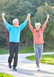 senior fitness woman man active sport exercise together running jogging hand celebrate celebration happy raised arm success victory team achievement teamwork winner up winning freedom healthy fit