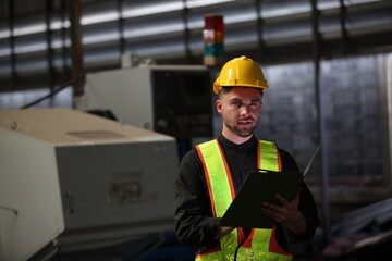 Wall Mural - worker or engineer working in factory with safety uniform , safety hat and safety glasses , image is safety concept or happy workplace