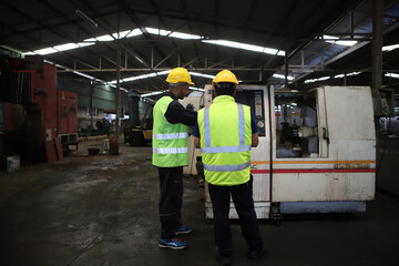 Wall Mural - worker or engineer working in factory with safety uniform , safety hat and safety glasses , image is safety concept or happy workplace