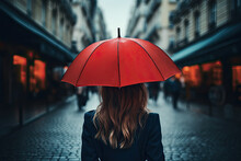 A Young Woman In A Black Clothes Walking Down A Rainy Evening City Street With An Red Umbrella Hat On Her Head. Back View.