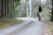 Reaper riding on gravel road in Autumn scenery. Ghost rider. Icelandic horse. Halloween.