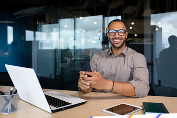 portrait of a young successful businessman, the man is smiling and looking at the camera, holding a 