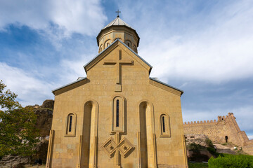 Wall Mural - tbilisi city and Narikala small castle with church inside on a cloudy day and blue clouds in the sky