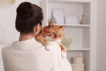 Poster - Woman with cute cat at home, back view. Space for text