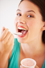 Poster - Eating, yogurt and portrait of woman with healthy food, diet or nutrition in studio with happiness. Happy, face and girl with spoon, yoghurt and strawberry flavor of dairy, product or snack for lunch