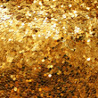 Gold sparkle glitter sequins 
 background. Golden backdrop with palliettes. Scattered аrom above close-up 