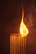a row of matches are lit on a dark background