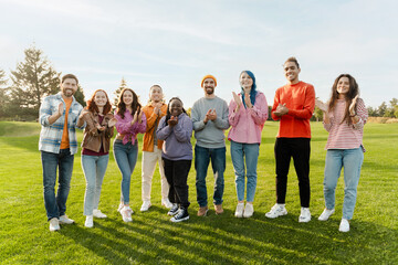 Wall Mural - Portrait of group of beautiful different multiracial friends wearing colorful clothes clapping hands