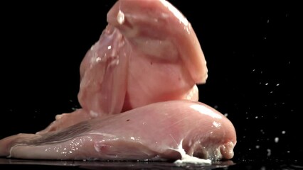 Poster - Chicken meat falls on a black wet table. Filmed on a high-speed camera at 1000 fps. High quality FullHD footage