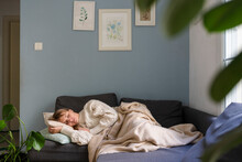 Stressed woman sleeping on sofa at home