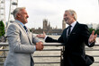 © Westend61 - Cheerful senior businessmen talking to each other on bridge near railing