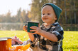 © Westend61 - Smiling boy wearing knit hat holding cup of hot chocolate on picnic