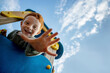 © Westend61 - Smiling boy on playing equipment showing palm under sky
