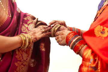 Wall Mural - Two women with henna tattoos adjust their bangles at an Indian wedding celebration.