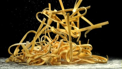 Wall Mural - Pasta falls on a board with flour. View from above. Filmed on a high-speed camera at 1000 fps. High quality FullHD footage