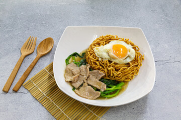 Wall Mural - Crispy egg noodles with sliced pork in Thick Gravy sauce