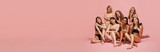 Elegant young beautiful women of different race, age and body sizes posing in lingerie against pink studio background. Concept of multi-ethnic beauty, feminisms, body acceptance, self-care