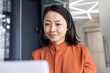 © Liubomir - Serious Asian woman listening online conversation close up, businesswoman with headset phone, online customer support worker, working with laptop, video call consultation.