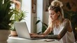 © radekcho - Creative young LGBT woman working on laptop. Girl with tattoo, designer freelancer or student work on computer laptop at table.