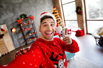 Poster - Portrait of handsome man take selfie toothy smile point finger you christmastime atmosphere apartment living room indoors