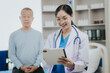 © Witoon - Female doctor talking taking care of her senior patient give support Doctor helping elderly patient with Alzheimer's disease A female attendant holds the hand of an elderly man