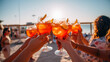 People toasting on a beach in a sunny day.