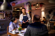 © Marko Geber - Bearded waiter talking to customers in sushi restaurant