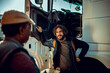 © Marko Geber - Young truck driver talking to colleague about to hit the road together