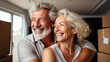 © PaulShlykov - Happy senior couple middle 60s aged woman and man at home with card boxes. Relocation, hospice, new home
