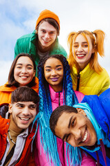 Multiracial group of young friends meeting outdoors in winter - Multiethnic students with colorful winter jackets and stylish outfits having fun in the city