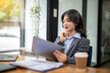 © Wasana - Business woman sitting and working using tablet to check news, information, marketing plan
